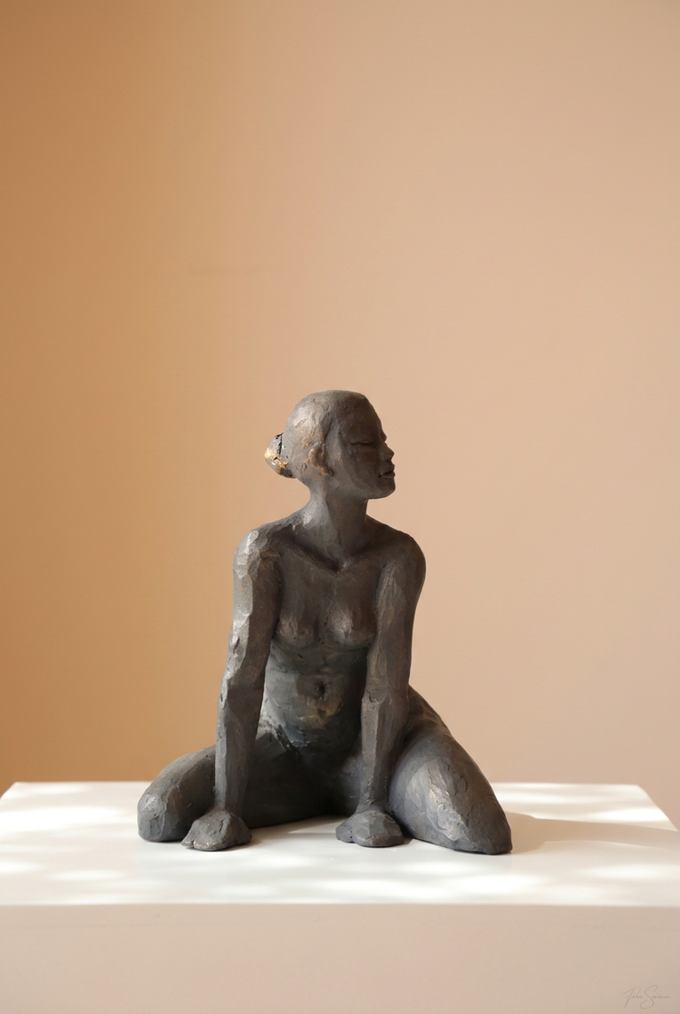 Manon d’Anne-Gaëlle Arnaud, femme assise en bronze sur un socle blanc, présentée en format vertical