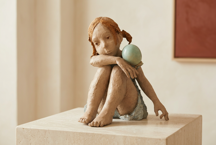Sculpture de Jurga posée sur un socle en pierre dans un intérieur clair